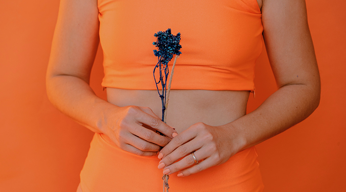 woman holding flower over stomach